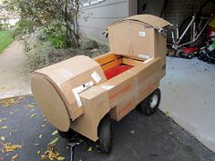 an open cardboard box sitting on the back of a truck in front of a garage