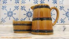 two wooden mugs sitting next to each other on top of a marble countertop