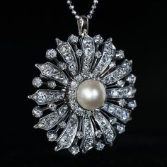 Circa 1870 A finely crafted in silver-topped gold (front - silver; back - gold) Victorian era brooch / pendant is designed as a stylized flowerhead, centered with a large (10 mm) natural saltwater pearl surrounded by chunky old cut diamonds (G-H-I color). Estimated total diamond weight is 8.20 carats. Diameter 43 mm (1 10/16 in.) Sold without chain Elegant Medallion Shaped Brooch Jewelry, Elegant Medallion Shaped Brooch, Elegant Yellow Gold Medallion Brooches, Victorian White Gold Pendant Brooches, Elegant Silver Medallion Brooch, Elegant Medallion Brooch For Formal Occasions, Elegant Flower Pendant Brooch Jewelry, Elegant Flower Pendant Brooch, Vintage White Pendant Brooches