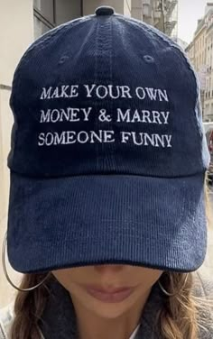 a woman wearing a blue hat that says make your own money and marry someone funny