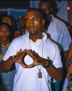 a man standing in front of a crowd holding his hands out to the side with both hands