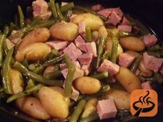 green beans, ham and potatoes are cooking in a skillet on the stove top