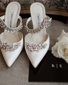 a pair of white shoes sitting on top of a table next to a flower bouquet