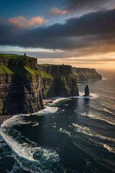 the cliffs and ocean at sunset with clouds in the sky