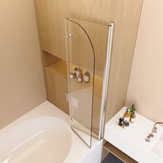 a bathroom with a sink, toilet and bathtub next to a wall mounted shower