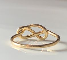 were highly symbolic in vintage jewelry, symbolizing infinite love. This would make a wonderfully unique wedding or engagement ring due to the romantic symbolism. The love knot/infinity knot represented the union of two souls arranged in the form of an infinity love knot. :) Ring weighs 1.3 grams. Band is stamped for 14k gold and is nice and sturdy despite it's dainty appearance. The ring is very comfortable to wear due to the low profile. The setting face measures 12.5 mm E to W and 8 N to S. C Infinity Ring Detail Wedding Jewelry, Wedding Infinity Jewelry With Ring Detail, Symbolic Infinity Jewelry For Anniversary, Handmade Infinity Promise Ring, Handmade Infinity Rings For Anniversary, Handmade Infinity Jewelry For Anniversary, Cabin Core Aesthetic, Infinity Knot Ring, Love Knot Ring