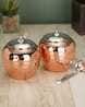 three copper colored pots sitting on top of a table next to a knife and fork