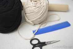 a ball of yarn next to a pair of scissors