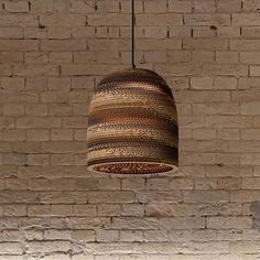 a lamp hanging from a brick wall