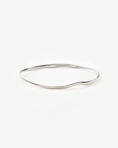 Molten Ripple Bangle | Sterling Silver. This Delicate Bangle Bracelet Features an Organic-Inspired Shape with Our Signature Molten Wavy Detailing. Designed to Slide on Easily, Wear Solo or Pair with Chunky Chains to Create a Bold Arm Stack. Metal: Rhodium Plated on Recycled Sterling Silver Small Band Width Varies from 2mm - 3. 8mm Inner Diameter: 60mm Weight: 17. 5g Medium Band Width Varies from 2mm - 3. 8mm Inner Diameter: 64mm Weight: 18. 8g Large Band Width Varies from 2mm - 3. 8mm Inner Diam Arm Stack, Small Band, Solid Gold Bracelet, Trending Bracelets, Initial Earrings, Trending Necklaces, Silver Plated Bracelet, Mixed Metal Jewelry, Earring Trends