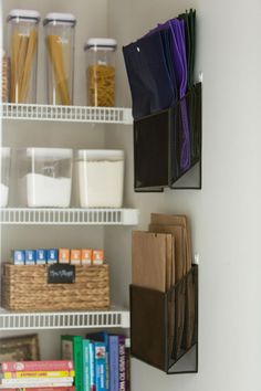 the shelves are organized with books, folders and other items in bins on them