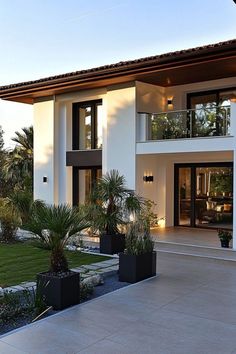 a large white house with black planters in front