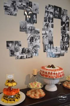 a table topped with cakes and pastries next to pictures on the wall behind them