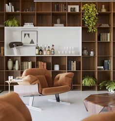 a living room filled with furniture and bookshelves next to a wall full of shelves