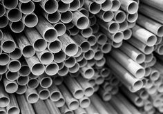 black and white photo of many pipes stacked together