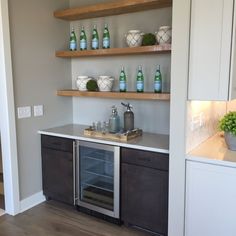 a kitchen with open shelving and bottles on the shelves