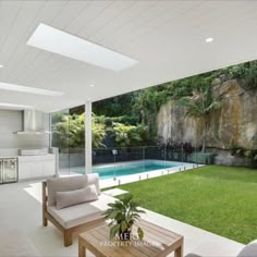 a living room with a couch and table next to a pool in the middle of it