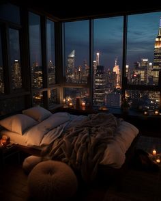 a bedroom with a view of the city at night