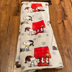 a snoopy dog blanket laying on top of a wooden floor