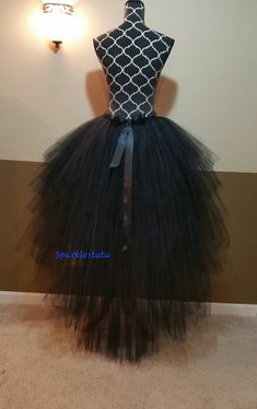 a black and white tulle skirt on display in front of a wall with lights