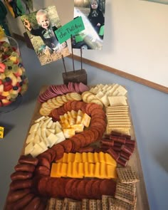 a platter filled with lots of different types of cheese and meats on top of a table