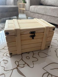 a wooden box sitting on top of a table next to a gray couch in a living room