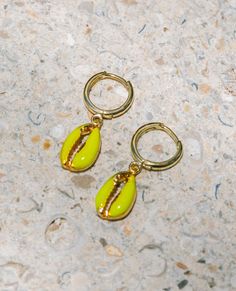 These Enamel Puka Shell Hoops are the perfect colorful beachy look for the summer! These 24k gold plated hoops are perfect swimming in the ocean sunrise to sunset! Trendy Gold Hoop Earrings For Vacation, Trendy Green Hoop Earrings For Beach, Nickel-free Yellow Jewelry For The Beach, Summer Gift Yellow Gold Earrings, Yellow Gold Drop Earrings For Summer, Ocean-inspired Green Jewelry For Vacation, Green Ocean-inspired Jewelry For Vacation, Yellow Earrings For Beach With Pierced Ears, Ocean-inspired Drop Earrings For Summer