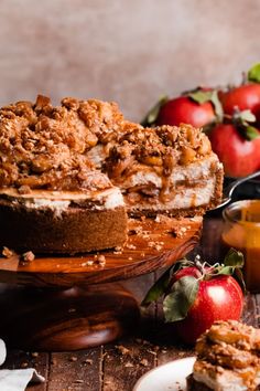 an apple crumb cake on a wooden platter next to apples and other fruit