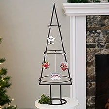 a small christmas tree sitting on top of a white table next to a fire place