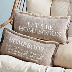 two pillows that say let's be homebodies on the back of a chair