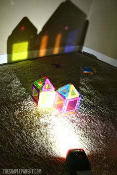 two colorful plastic blocks sitting on the floor next to a cell phone