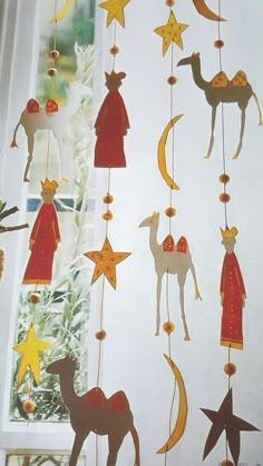 an image of christmas decorations hanging on the window sill with stars and reindeers