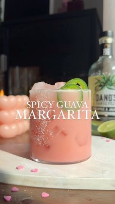 a pink drink with a lime slice on the rim and spicy guava margarita