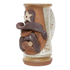 a brown and white ceramic vase with a star on it's head in the shape of a cowboy