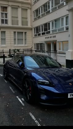 a blue sports car parked on the side of the road in front of some buildings