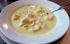 a white bowl filled with soup on top of a table