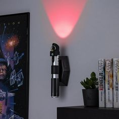 a star wars movie poster is on the wall next to a lamp and some books