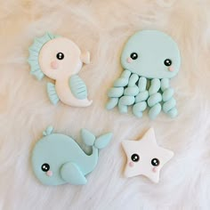 three cookies shaped like sea animals sitting on top of a white fur covered floor