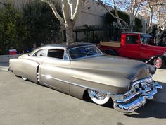 an antique car is parked on the street