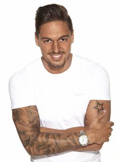 a man with tattoos on his arms posing for a photo in front of a white background