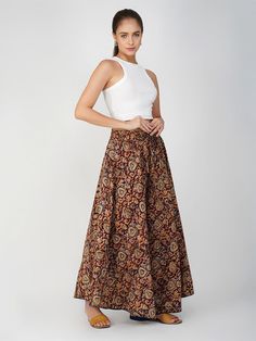 Our Venessa printed skirt, made from soft cotton fabric, features an A-line silhouette perfect for most body types. This regular-fit Kalamkari skirt with an elasticated waistband is a great option for all-day wear, especially during the summer months. Kalamkari is a highly popular form of block-printed cotton textile produced with the help of kalam, meaning pen. During the process, a sharp-pointed pierced bamboo regulates the flow of color/organic dye on the fabric. This maroon-colored skirt comes with one pocket, making it an ideal casual-wear wardrobe staple. To add some extra fun, you can pair it with a monotone shirt or top and elevate your style effortlessly. Material: Cotton Style/Print: Kalamkari Waist: 30” Length: 39” Fit: A-line Occasion: Casual Color: Maroon Lining: No Kalamkari Skirts, Blue Lily, Cotton Textile, Printed Skirt, Skirt For Women, Summer Months, Matching Dresses, Printed Skirts, Cotton Style