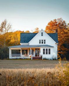 a large white house sitting in the middle of a field