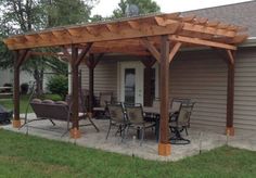 a covered patio with chairs and tables in front of a house on a lawn area