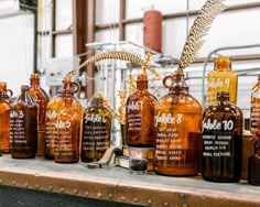 many brown glass bottles are lined up on a table with a feather in the top