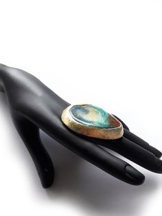 "Huge Brutalist Ring, Large Blue Gold Ring, Contemporary Ring, Bold Blue Ring, Modern Blue Artisan, Handmade, Unique, Unusual, KEEP IT AWAY FROM hair spray, nail polish remover, and other chemicals.  ADJUSTABLE FOR BIG SIZES Materials: Mixed Media, Brass Shank, Resin, 14K Gold Plating on Cabochon Measure approx.: 5.3 cm x 4.5 cm = 2.2\" x 1.8\" All parts are handmade. Each cabochon is slightly different. You are going to get random picked ring. --------- More Statement Rings here https://www.ets Artsy Round Blue Jewelry, Artsy Blue Round Jewelry, Blue Metal Open Ring Jewelry, Blue Open Ring Metal Jewelry, Oval Blue Brooch Jewelry, Blue Oval Brooch Jewelry, Oval Blue Brooch, Artsy Blue Metal Jewelry, Unique Patina Rings As Gift