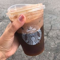 a person holding up a cup of coffee