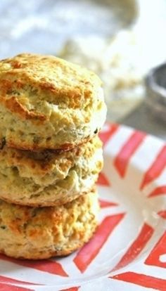 three biscuits stacked on top of each other on a red and white plate with silverware