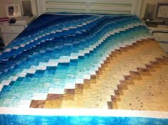 a bed with a blue and yellow quilt on it