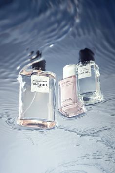 three bottles of chanel perfume sitting in the water