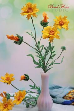 a vase with yellow flowers in it sitting on a table